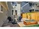 Landscaped patio area featuring a brick paver floor, dining table with umbrella and custom wooden planter at 9826 E 27Th Dr, Denver, CO 80238