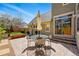 Outdoor patio with brick pavers, dining table, umbrella and seating with steps leading to a sliding glass door at 9826 E 27Th Dr, Denver, CO 80238