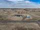 Aerial view of the property showcasing the house, detached garage, and surrounding landscape at 253 E 8Th Ave, Byers, CO 80103