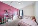 bedroom features playful pink walls and a cute dollhouse at 253 E 8Th Ave, Byers, CO 80103