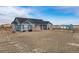 Ranch-style home with a blue exterior, dark roof, and a detached garage on a spacious lot at 253 E 8Th Ave, Byers, CO 80103