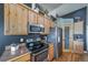 Modern kitchen with stainless steel appliances, wooden cabinets, and a convenient layout, blending style and functionality at 253 E 8Th Ave, Byers, CO 80103