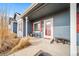 Covered front porch featuring red shutters, a sitting area, and a painted blue exterior at 253 E 8Th Ave, Byers, CO 80103
