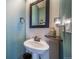 Cozy powder room features a pedestal sink, modern fixtures, and a decorative mirror at 253 E 8Th Ave, Byers, CO 80103