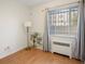 Cozy bedroom with hardwood floors, window with blinds, and a stylish floor lamp at 1454 Jersey St # 2, Denver, CO 80220