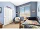 Comfortable bedroom featuring light blue walls, carpeted floors, and natural light from the window with views at 12278 Stone Timber Ct, Parker, CO 80134