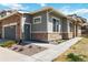 Exterior corner of a gray home with stone accents, a gray garage door, and a gray front door with landscaping at 12278 Stone Timber Ct, Parker, CO 80134