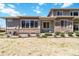 Rear exterior view of a home with a well-kept lawn and outdoor patio with a stone feature at 12278 Stone Timber Ct, Parker, CO 80134