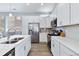 Modern kitchen featuring stainless steel appliances, white cabinets, and quartz countertops at 12278 Stone Timber Ct, Parker, CO 80134