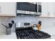 Close up of a well-equipped kitchen featuring stainless steel appliances, white cabinets, and modern tile backsplash at 12278 Stone Timber Ct, Parker, CO 80134