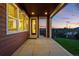 Covered patio with stylish wood siding, offering a view of the manicured lawn and sunset at 4825 Basalt Ridge Cir, Castle Rock, CO 80108