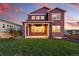 Red two-story home featuring a well-manicured lawn and landscaping in backyard at 4825 Basalt Ridge Cir, Castle Rock, CO 80108