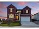 Beautiful two-story home with a two car garage and a combination stone and siding exterior under a colorful sky at 4825 Basalt Ridge Cir, Castle Rock, CO 80108