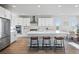 Bright, open kitchen featuring stainless steel appliances, a large island with seating, and white cabinetry at 4825 Basalt Ridge Cir, Castle Rock, CO 80108