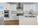Bright kitchen showcasing a stainless steel range, white cabinets, and stylish backsplash above the sink at 4825 Basalt Ridge Cir, Castle Rock, CO 80108