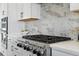 Close up of kitchen with stainless steel range, marble backsplash, and white cabinets at 4825 Basalt Ridge Cir, Castle Rock, CO 80108