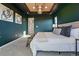 A bedroom with a tray ceiling with art and a modern chandelier, and stylish wall art at 4825 Basalt Ridge Cir, Castle Rock, CO 80108