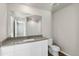 Bathroom featuring large mirror, white cabinets, light countertops and walk-in shower at 3036 Oxley St, Strasburg, CO 80136