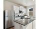 Kitchen showcasing stainless steel appliances, grey countertops, white cabinetry, and a kitchen island at 3036 Oxley St, Strasburg, CO 80136