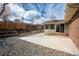 Enclosed backyard showcasing a concrete patio, rock garden, and sunroom entrance for relaxation at 9390 W Alabama Dr, Lakewood, CO 80232