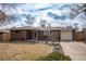 Charming brick home with a well-manicured lawn, rock garden, and driveway at 9390 W Alabama Dr, Lakewood, CO 80232