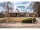 Charming red brick ranch-style home with manicured lawn and mature trees at 9390 W Alabama Dr, Lakewood, CO 80232