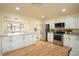 Open kitchen boasts white cabinets, stainless steel appliances, and a large island at 9390 W Alabama Dr, Lakewood, CO 80232