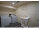 Basement laundry room featuring washer, dryer, utility sink, wood look flooring, and white walls at 9390 W Alabama Dr, Lakewood, CO 80232