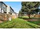 Spacious backyard with a lush green lawn, mature trees, and a wooden fence for privacy at 1055 Milo Cir # A, Lafayette, CO 80026