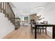 Open-concept dining and living area with stone fireplace, wood floors and staircase at 1055 Milo Cir # A, Lafayette, CO 80026