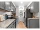 Galley kitchen with gray cabinets, granite countertops, stainless appliances, and wood-look flooring at 1055 Milo Cir # A, Lafayette, CO 80026