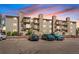 Exterior view of a multi-story apartment building featuring stone accents and balconies at sunset at 381 S Ames St # E305, Lakewood, CO 80226