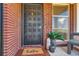 Inviting front porch with decorative door, 'hello' doormat, potted plants, and chair at 5975 S Milwaukee Way, Centennial, CO 80121