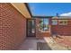Close-up of brick facade with windows and front door with visible house numbers at 5975 S Milwaukee Way, Centennial, CO 80121