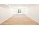 Spacious basement with light hardwood floors and wainscotting below a window at 38 Sedgwick Dr, Cherry Hills Village, CO 80113