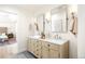 Bright bathroom featuring double sink vanity with marble countertops and wood cabinets at 38 Sedgwick Dr, Cherry Hills Village, CO 80113