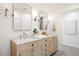 Bright bathroom featuring double sink vanity with marble countertops and wood cabinets at 38 Sedgwick Dr, Cherry Hills Village, CO 80113