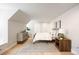 Sunlit bedroom with a sloped ceiling, stylish decor, and hardwood floors at 38 Sedgwick Dr, Cherry Hills Village, CO 80113