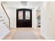 Elegant foyer with wood floors, features a striking dark wood double door entrance and stylish staircase at 38 Sedgwick Dr, Cherry Hills Village, CO 80113