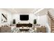 Well-decorated living room with contemporary furniture, a large TV, and a staircase at 38 Sedgwick Dr, Cherry Hills Village, CO 80113
