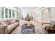 Spacious living area featuring hardwood floors and large windows, seamlessly connects to the dining space at 38 Sedgwick Dr, Cherry Hills Village, CO 80113
