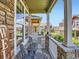Relaxing front porch featuring stone pillars and a charming seating area overlooking the community at 13638 Garfield St # C, Thornton, CO 80602