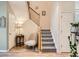 Bright foyer features a staircase with carpeted steps, a decorative chair, and wood-look flooring at 13638 Garfield St # C, Thornton, CO 80602