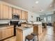 Bright kitchen boasts an island with seating, warm wood cabinets, stainless steel appliances, and an open layout at 13638 Garfield St # C, Thornton, CO 80602