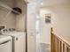 Upstairs laundry area with washer, dryer, wire shelving, and access to hallway at 13638 Garfield St # C, Thornton, CO 80602