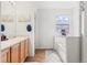 Bright bathroom with double sinks, decorative window, and bathtub, offering a clean and functional space at 6650 Stagecoach Ave, Firestone, CO 80504