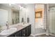 Elegant bathroom featuring double sinks, a soaking tub, and a glass-enclosed shower for a spa-like experience at 2190 Coyote Creek Dr, Fort Lupton, CO 80621
