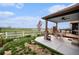 Comfortable covered patio with a ceiling fan and dining area overlooking a lush golf course at 2190 Coyote Creek Dr, Fort Lupton, CO 80621