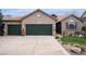 Charming brick home featuring a three-car garage, manicured lawn, and decorative exterior details at 2190 Coyote Creek Dr, Fort Lupton, CO 80621
