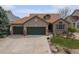 Charming brick home featuring a three-car garage, manicured lawn, and decorative exterior details at 2190 Coyote Creek Dr, Fort Lupton, CO 80621